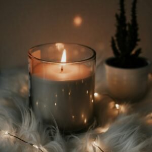 Lit candle in a ceramic vessel in warm light